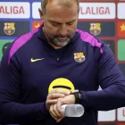 Hansi Flick mira el seu rellotge ahir durant la roda de premsa. - EFE/ALBERTO ESTÉVEZ