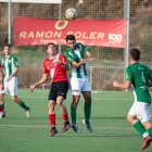 Un jugador de cada equip lluita per rematar amb el cap una pilota dividida. - PAU PASCUAL