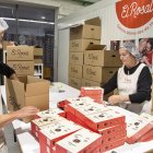 Dos voluntàries posant arrugats en caixes preparades per a aquestes festes.