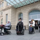 Usuaris de cadira de rodes davant l’estació de trens de Lleida. - S.E.