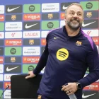 Hansi Flick, somrient mentre s’asseu a la sala de premsa.