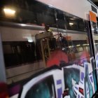 Un treballador netejant un grafiti d'un tren de Rodalies a la base de manteniment de Renfe a Cornellà de Llobregat