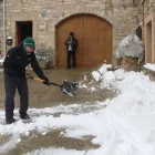Un home treu la neu de l’entrada de casa seua a Vimbodí i Poblet. - ACN