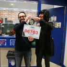 Dos treballadors de l’administració Doña Pilar de Salou, ahir amb el cartell del primer premi. - ACN / MAR ROVIRA