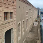 Al fons, operaris treballant en la façana dels Docs que dona a les vies. - JMA