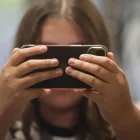 Imatge d’arxiu d’una nena consultant el telèfon mòbil. - EFE