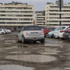 Un cotxe circulant pel solar que funciona com a pàrquing darrere del col·legi Frederic Godàs. - JORDI ECHEVARRIA