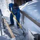 Un operari de Port Ainé treballa retirant la neu d’un dels accessos de l’estació. - ACN