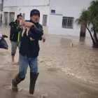 Un home evacua el seu gat pel perill de les inundacions en una localitat de Cadis. - EUROPA PRESS