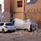 Dos vehicles estacionats en un carrer de Tortosa afectats per l’esfondrament de murs pel vent. - ARIADNA ESCODA/ACN