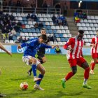 Jordi Puig intenta controlar una pilota davant la pressió de Matovu sobre la irregular gespa del Camp d’Esports. - ÀLEX SAMPER