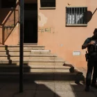 Un agent davant l’entrada de l’habitatge on es va cometre el crim. - EFE