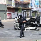 Un policia vigila prop d’un cotxe incendiat a Guadalajara, capital de l’estat de Jalisco. - EUROPA PRESS / CONTACTO / DIANA MARQUEZ