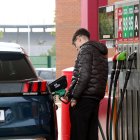 Un jove carregant el dipòsit en una gasolinera.