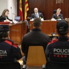 L'acusat de ruixar la dona amb líquid inflamable i calar-li foc a Artesa de Segre, custodiat per dos mossos durant el judici a l'Audiència de Lleida.