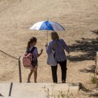 Persones amb parasol en un parc de Lleida.