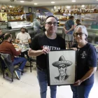 Els responsables del local posen amb un dibuix del Coyote firmat per Ermengol. - EDGAR ALDANA