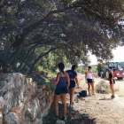 Un grup de quatre joves participa en la restauració d’un mur de pedra seca. - FUNDACIÓ ESCOLTA JOSEP CAROL