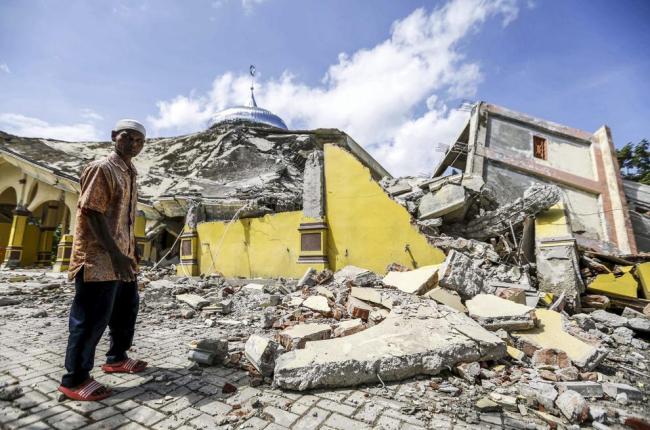 Un ciudadano indonesio inspecciona una mezquita destruída la provincia de Aceh.