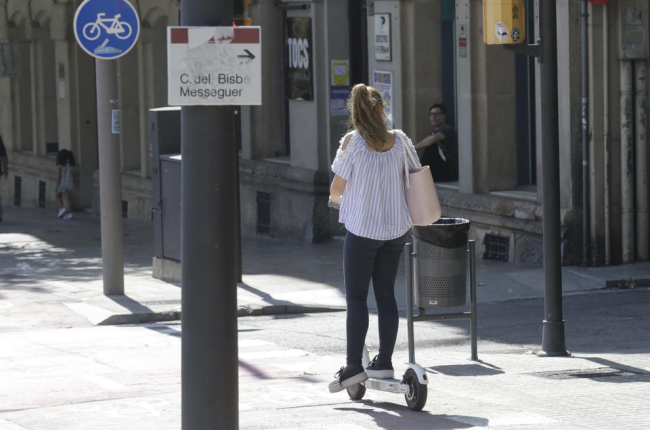 Una jove circula amb un patinet elèctric per rambla d’Aragó pel carril bici, ahir.
