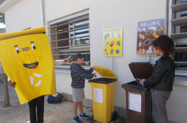 La mascota de la campaña, al lado de los puestos de reciclaje. 