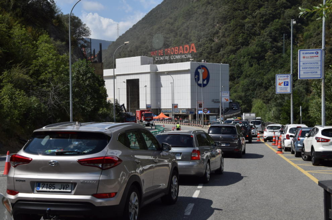Retenciones, paso alternativo de camiones y desvío de coches por la mañana en Andorra (izquierda) mientras se iniciaban los trabajos para asegurar la ladera (derecha).