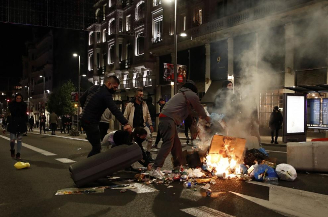 Individuos incendiando cubos de basura en la Gran Vía de Madrid, el sábado por la noche. 