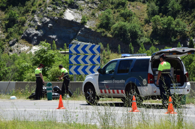 Agentes de los Mossos junto a la moto accidentada ayer en la N-260 en El Pont de Bar. 