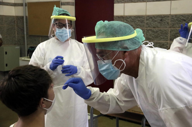 Técnicos realizan una PCR a un menor en una escuela de Girona.