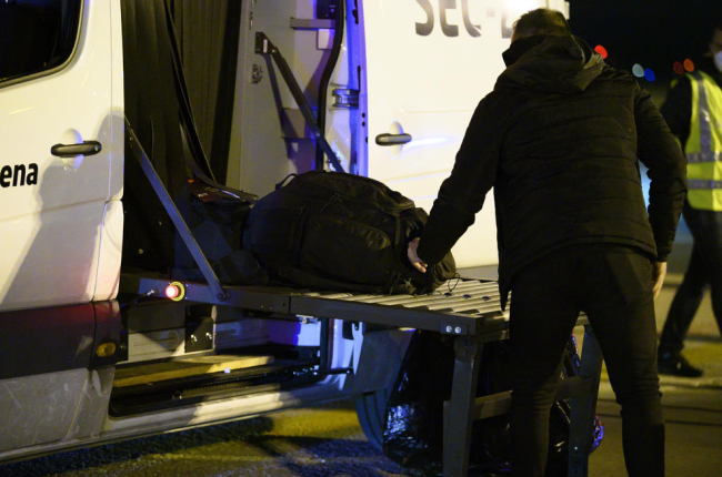 Un dels espanyols repatriats de la ciutat xinesa de Wuhan pel risc de coronavirus carrega maletes en un autobús abans de ser traslladat a l'hospital per la quarantena el 31 de gener.