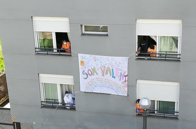 Els treballadors de la residència del Pont de Suert penjant una pancarta a la façana de l’edifici.