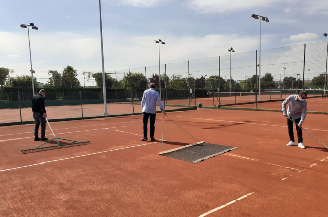 Un operari desinfecta l'entrada al recinte del Club Tennis Urgell, que també va posar a punt les pistes per a la reobertura avui de les instal·lacions