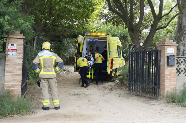 Sanitaris atenent ahir el ferit per inhalació de fum.
