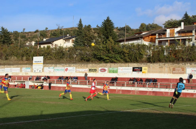 Un jugador del Oliana trata de llegar a la pelota ante la presión de varios jugadores del Bellpuig.