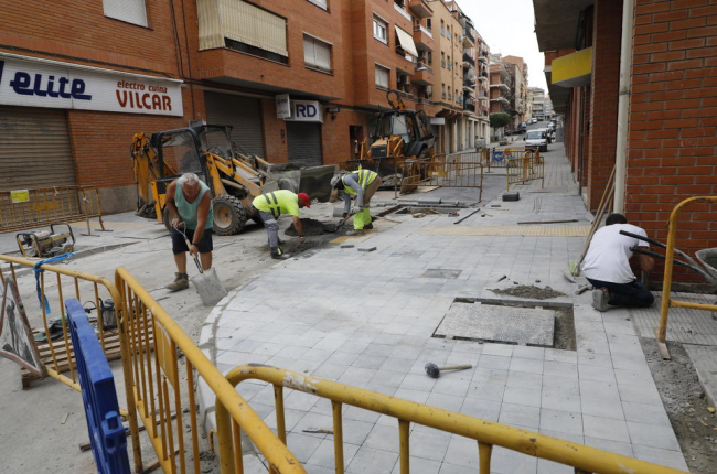 Operaris ultimen les obres de millora d’un tram del carrer les Roses, a la Bordeta.