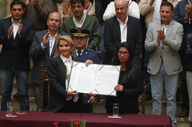 Áñez (esq.) amb el document que convoca noves eleccions.