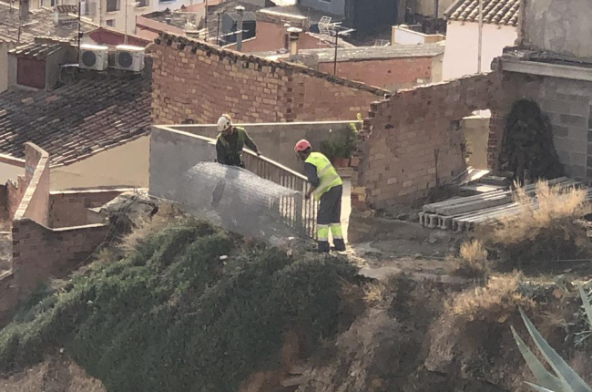 Operarios instalando mallas en el talud de la calle Obradores.