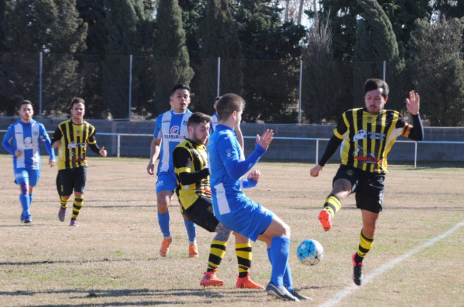 Jugadores de ambos conjuntos disputan un balón divido en un lance del partido.