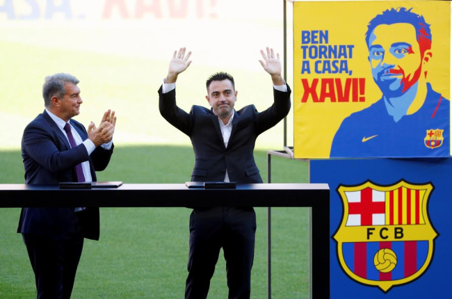 El nou entrenador del FC Barcelona, Xavi Hernández, al costat del president del club, Joan Laporta, saluda els aficionats que s'han citat a les grades del Camp Nou durant l'acte de presentacion com a entrenador blaugrana.