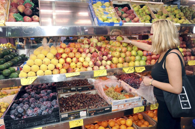 Foto de archivo de una mujer comprando fruta en un supermercado.