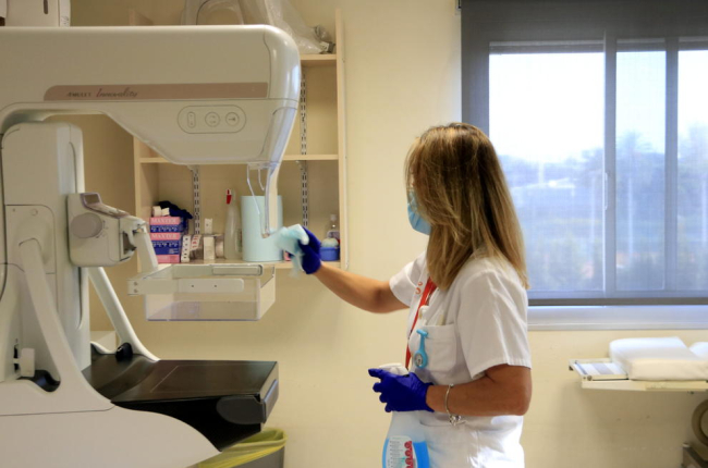 Una sanitaria desinfecta un mamógrafo antes de utilizarlo de nuevo para el cribado o programa de detección precoz del cáncer de mama, en el Instituto Catalán de Oncología (ICO).