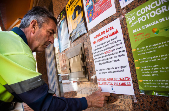 L’agutzil de Cervià desplega cartells amb el ban municipal que prohibeix consumir l’aigua de l’aixeta.