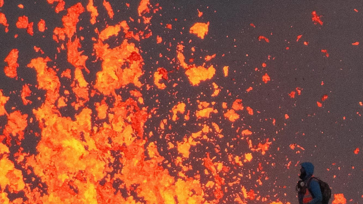 Un científic treballa a la vora d’una fissura per observar lava expulsada en una erupció d’un volcà avui, a la península Reykjanes, a prop a la ciutat de Grindavik (Islàndia).