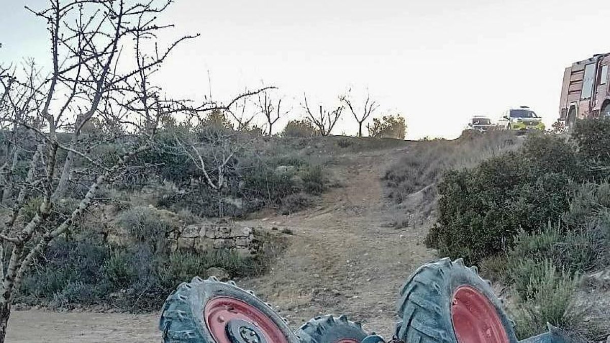 Imatge del tractor bolcat ahir a Castelldans. A la dreta, llargues cues a la tarda a l’autovia per un accident a Castellnou de Seana.