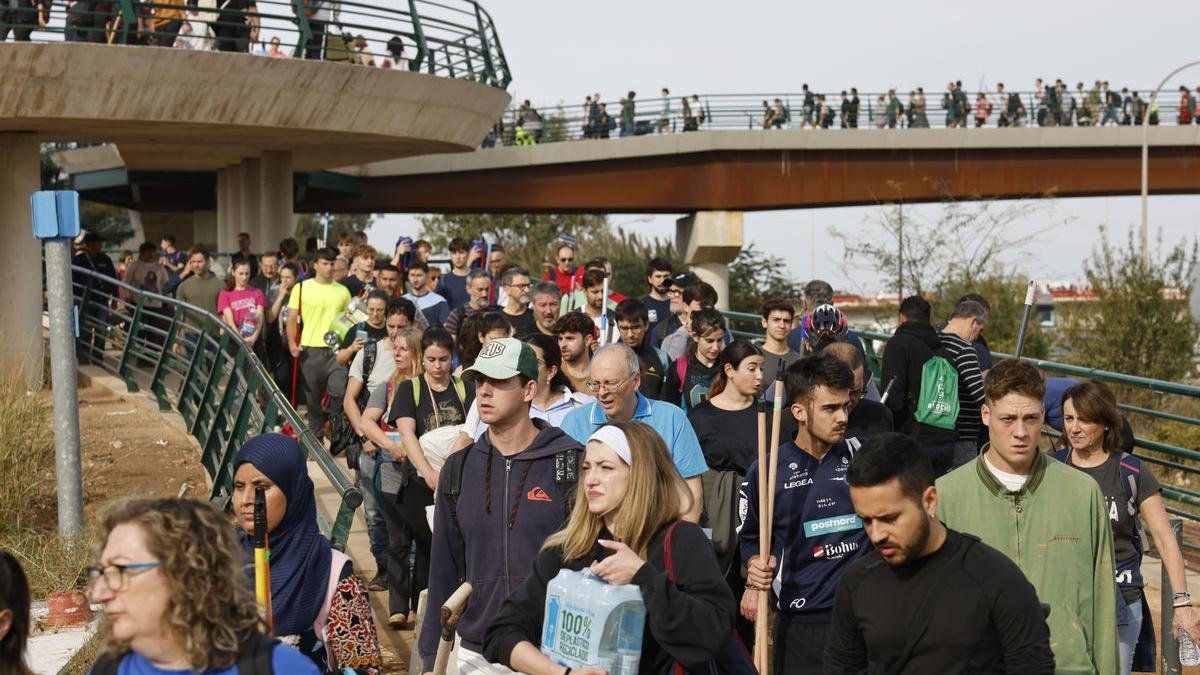 Centenars de persones copen el pont que uneix la ciutat de València amb pedanies arrasades per la dana per oferir ajuda. - DEFENSAGOB