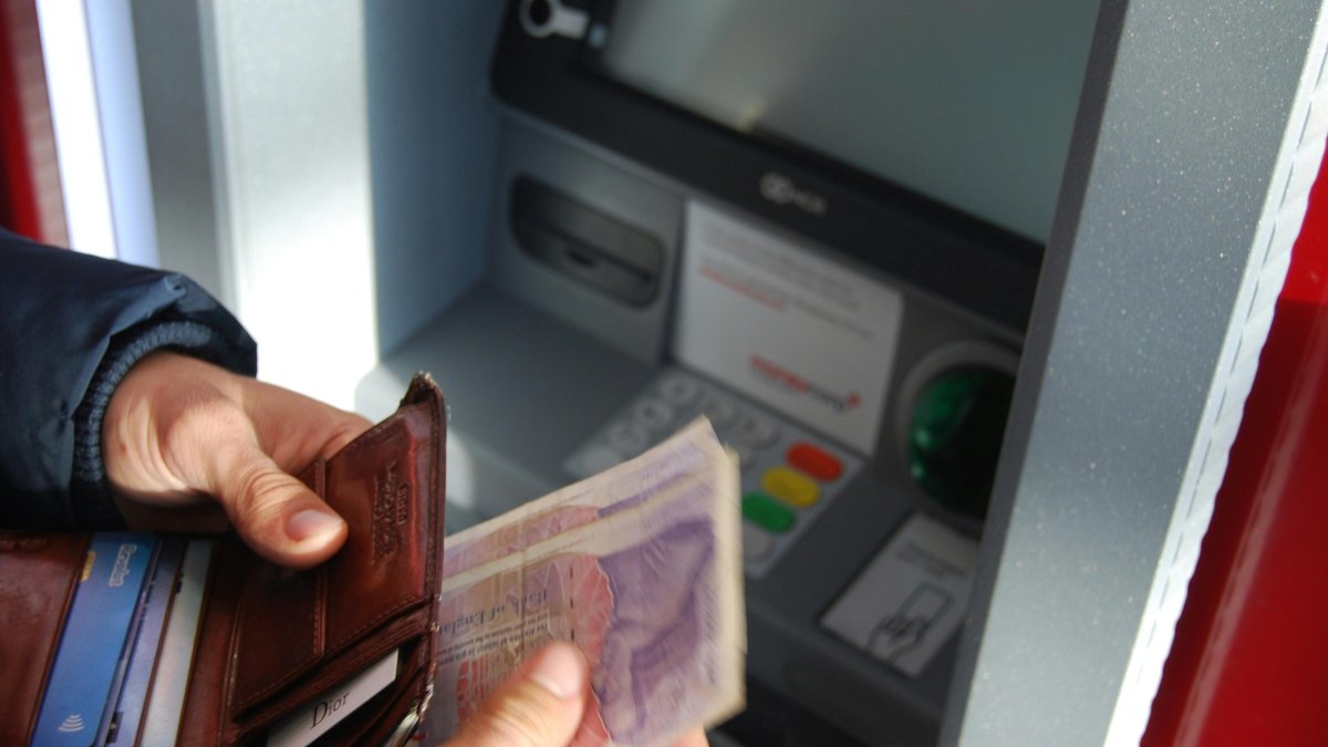 Una persona retira dinero en efectivo de un cajero automático.