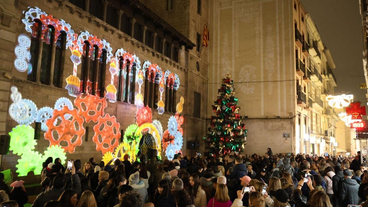 La plaza de la Paeria, a rebosar ayer tarde con decenas de personas que no queisieron perderse el nuevo ‘mapping’ y el encendido de las luces navideñas. - AMADO FORROLLA
