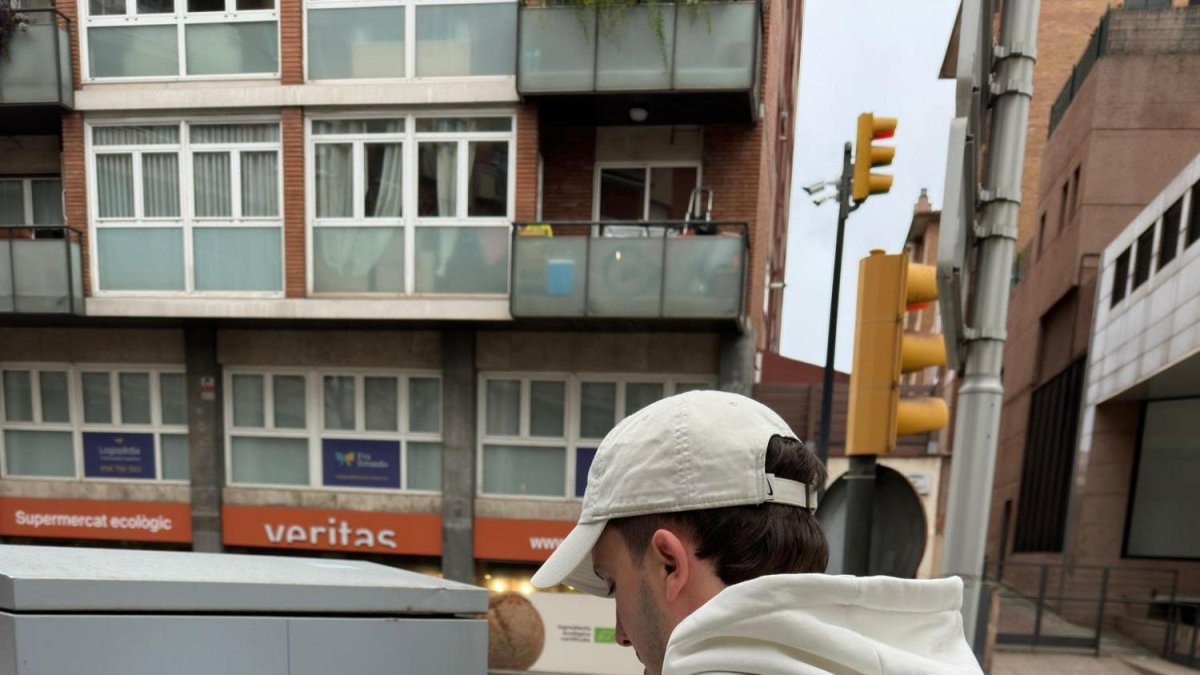 Jordi Villegas colgando uno de sus carteles en la calle