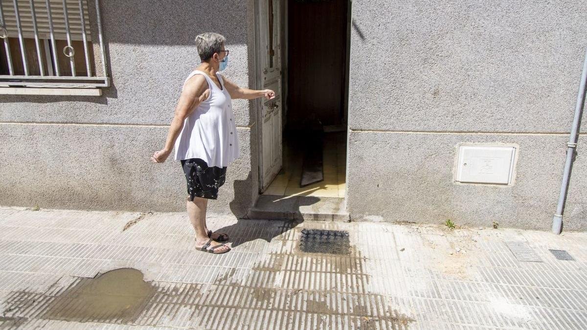 Una veïna mostra l’habitatge d’on surten les pudors a causa d’aigües fecals. - JORDI ECHEVARRIA