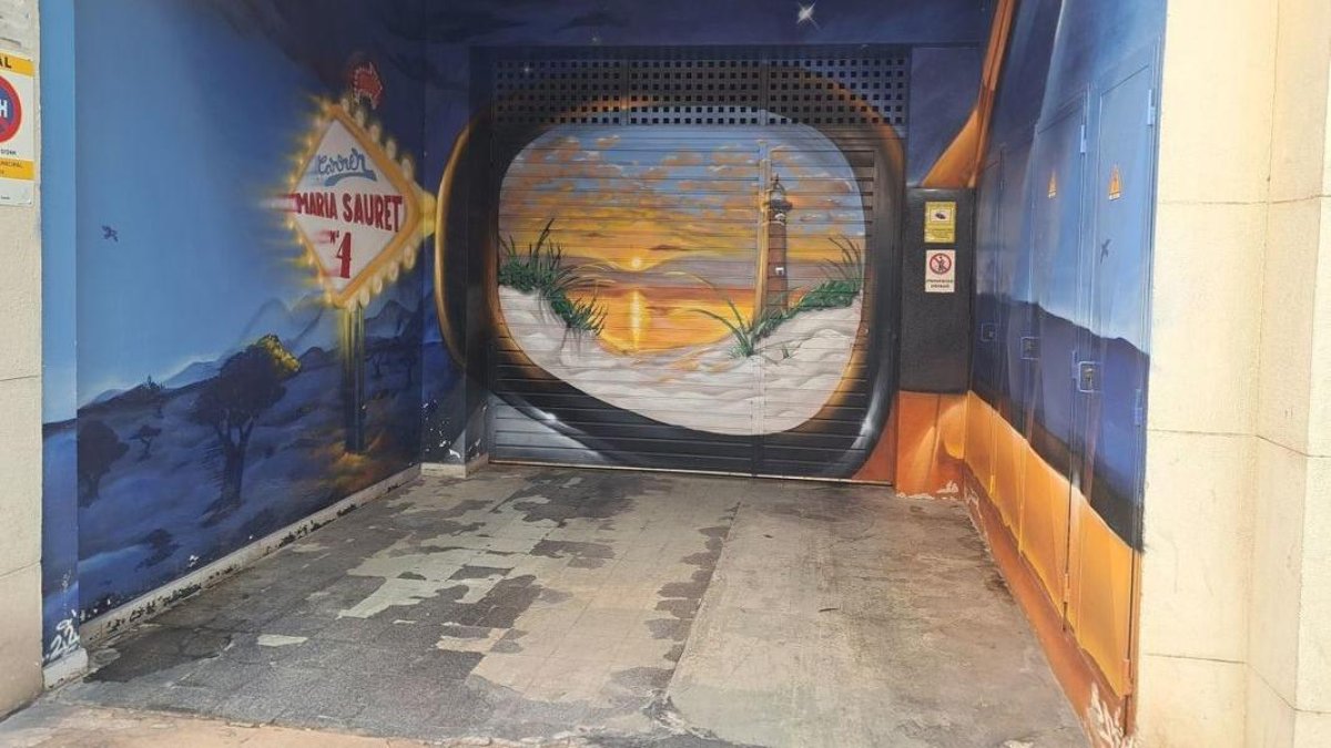 L’entrada d’un aparcament comunitari del carrer Maria Sauret amb un mural artístic. - SCD